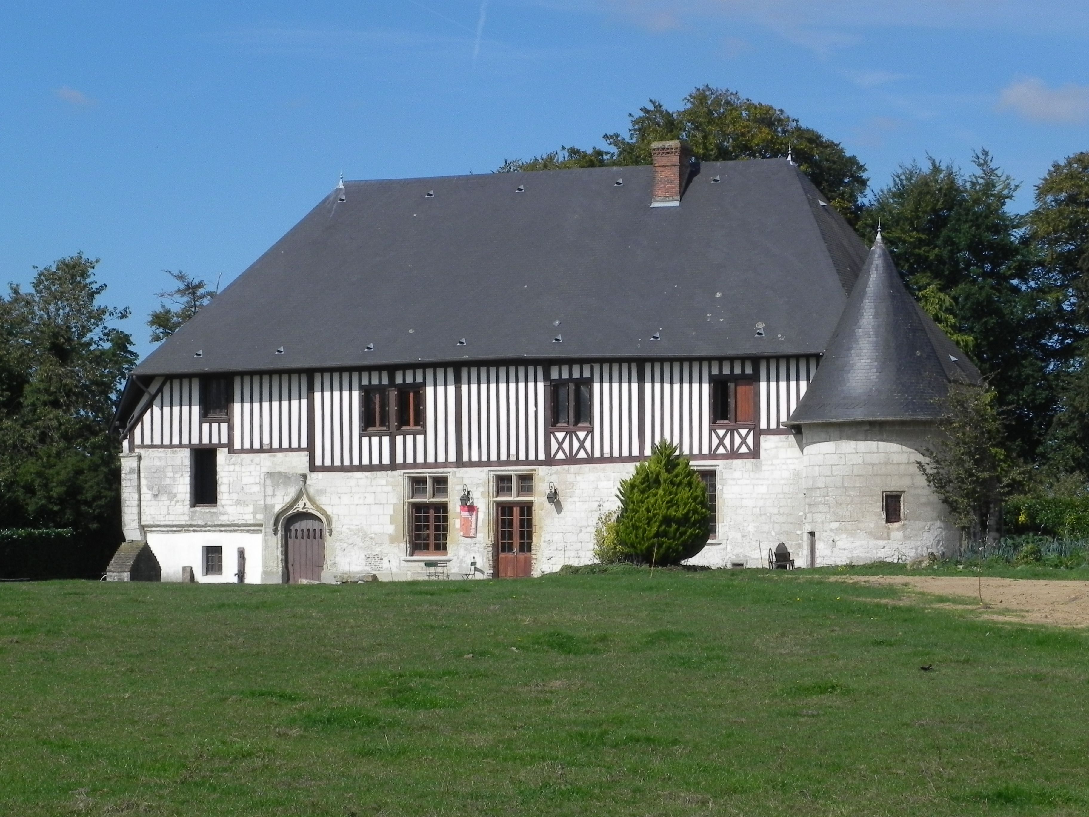A picturesque historic French manor with a turret in a lush landscape, perfect for travel inspiration.