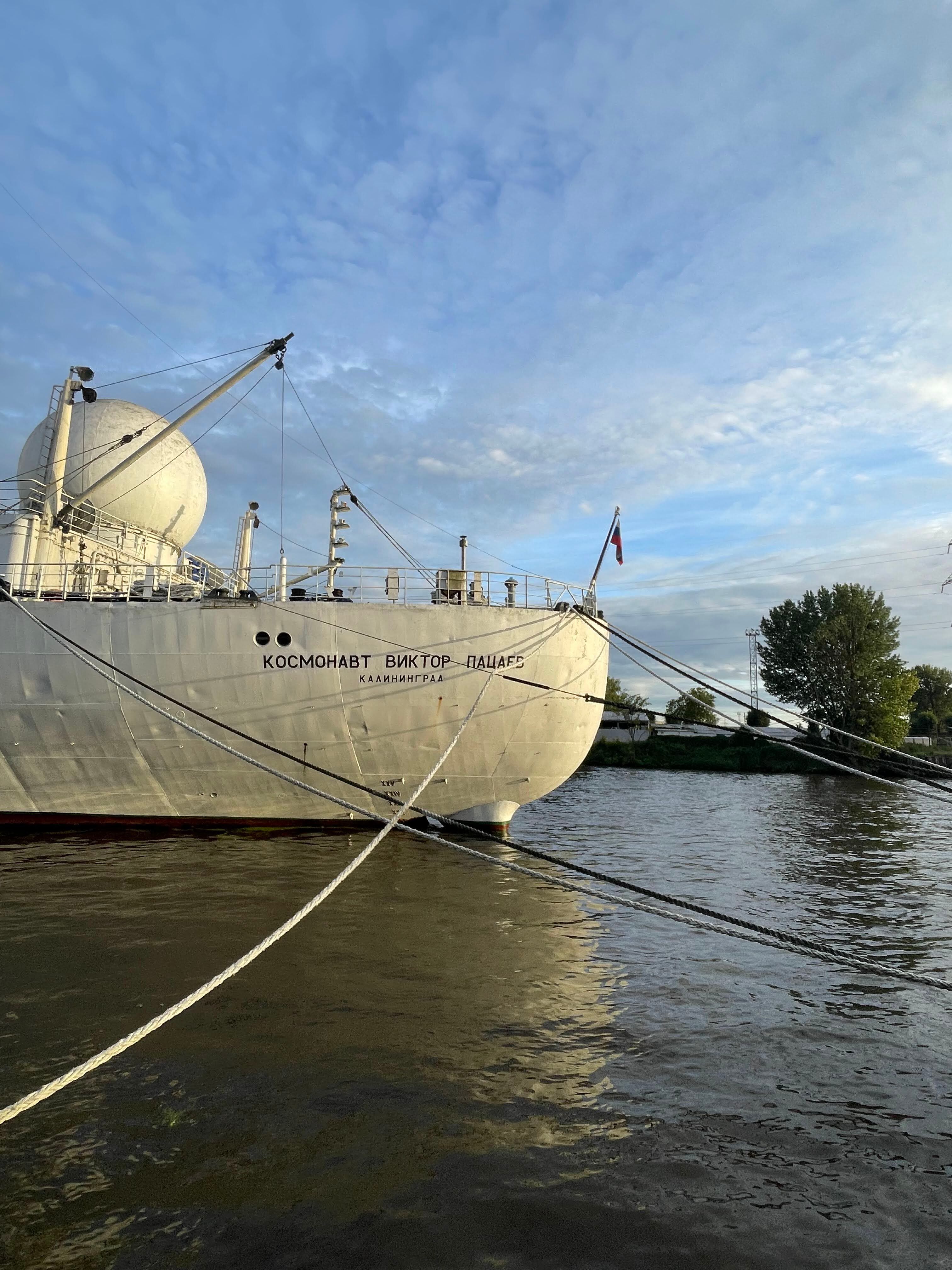A ship docked at a Kaliningrad port, surrounded by water and sky.