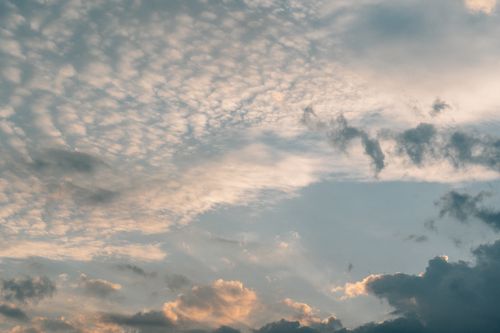 Free Beautiful sky filled with soft clouds and warm sunset tones creating a peaceful atmosphere. Stock Photo