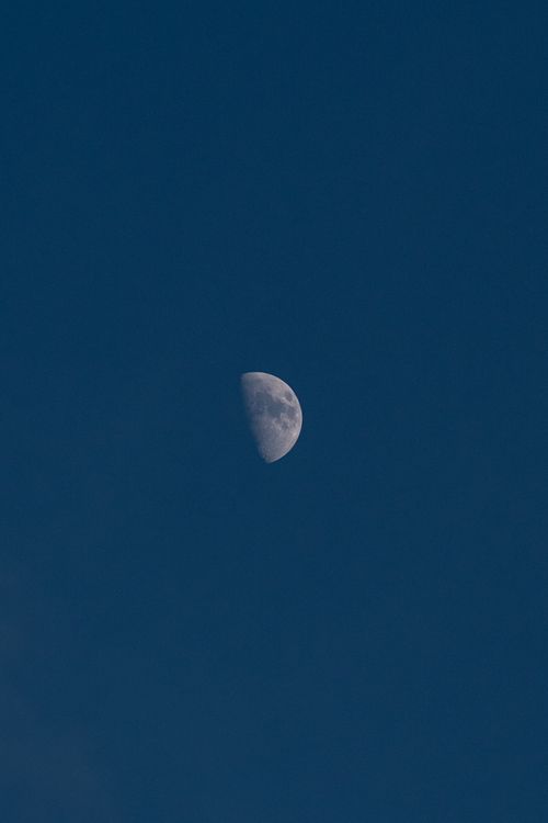 Free A captivating view of a crescent moon set in a vast, clear night sky, perfect for lunar and astronomy themes. Stock Photo