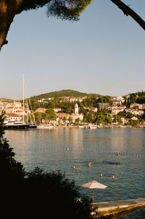 Free Scenic view of Cavtat harbor with sailboats and swimmers on a summer day. Stock Photo