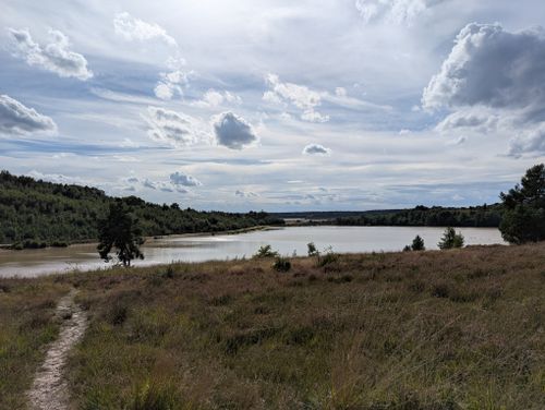 Free Serene landscape with a lake and cloudy sky in Maasmechelen, Belgium. Stock Photo