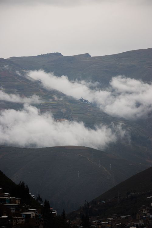 Free Serene view of mountains enveloped in mist with a cloudy sky and atmospheric ambiance. Stock Photo