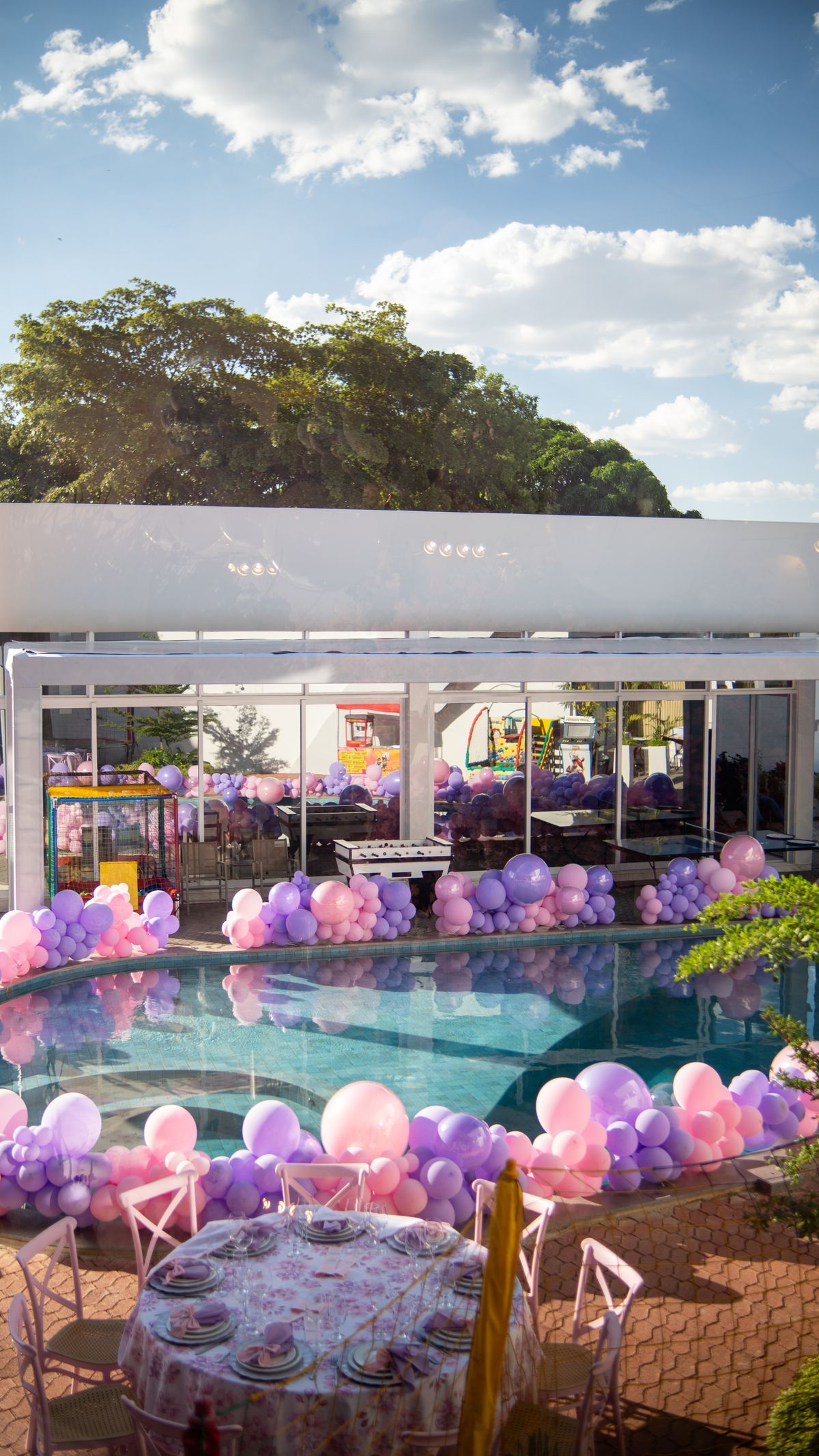 Vibrant outdoor pool party with pastel balloons and cheerful atmosphere. Stock Photo.