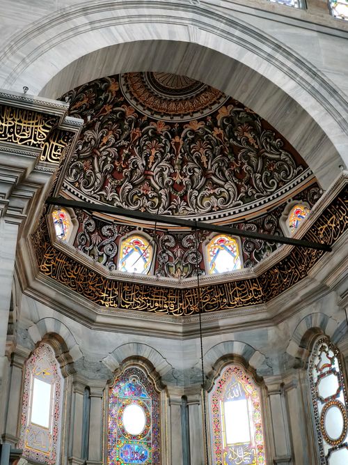 Free Intricate designs and stained glass adorn the interior dome of a historic mosque, showcasing Islamic artistry. Stock Photo
