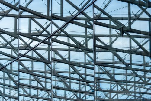 Free Abstract view of modern architectural structure with glass and metal beams reflecting sky. Stock Photo