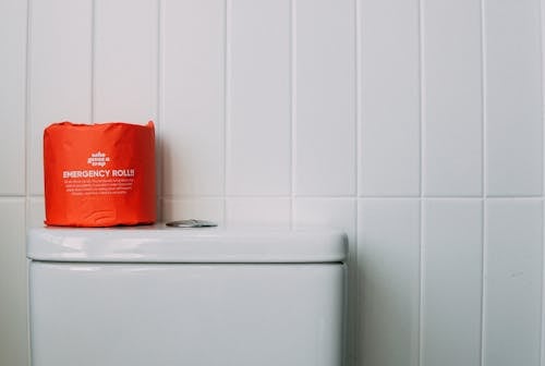 Free Red Toilet Paper on White Ceramic Toilet Stock Photo