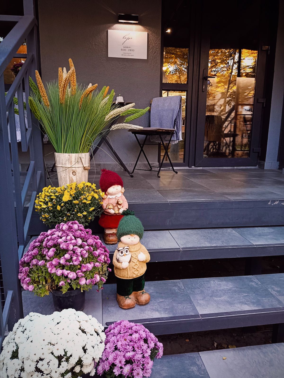 Cozy autumn porch decor with flowers and a chair
