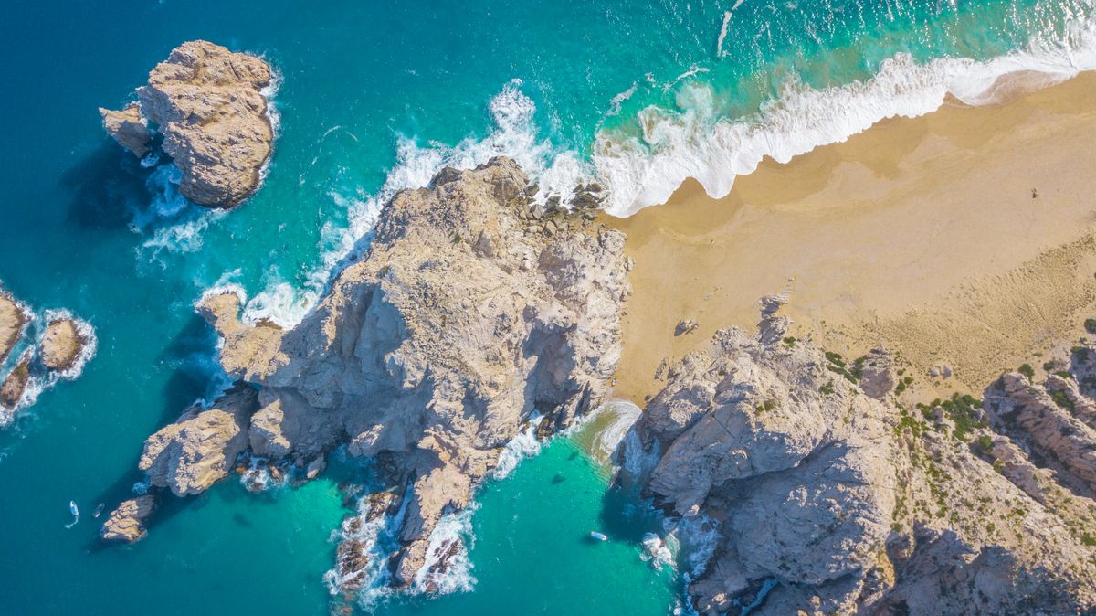 Una vista aérea impresionante de la playa icónica de Cabo San Lucas mostrando la costa rocosa