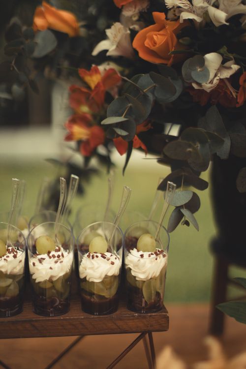 Free Charming dessert setup with whipped cream and grapes beside vibrant floral decor. Stock Photo