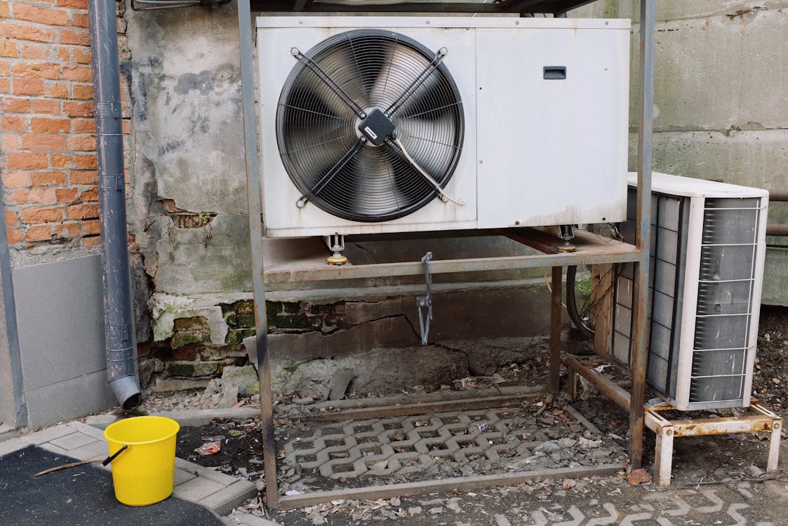 Free Air conditioner unit near wall of modern building on street Stock Photo