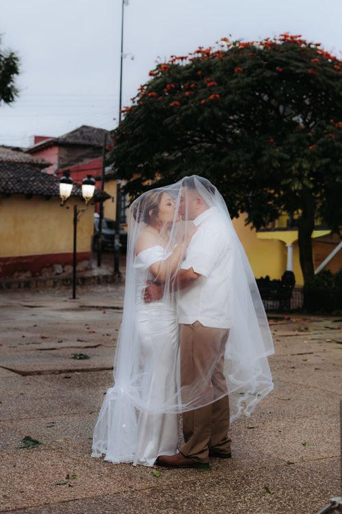 Free Bride and groom share a tender moment under a veil in Comitán de Domínguez, Mexico. Stock Photo