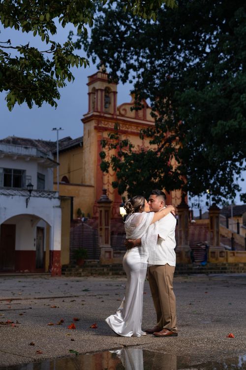 Free A couple embraces outdoors against a historic church in Comitán de Domínguez, México. Stock Photo