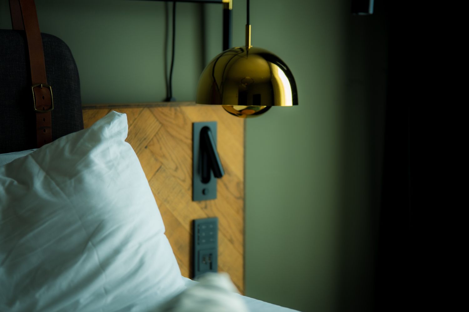Warm bedroom sanctuary with textured pillows and sculptural brass task lamp