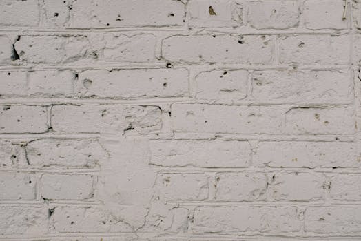 Detailed texture of an old weathered white brick wall, ideal for background use.