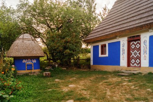 Free Explore a colorful mud hut with thatched roof in a Ukrainian open-air museum setting. Stock Photo