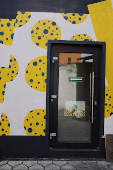 Bright and artistic entrance featuring geometric patterns and bold colors on a modern facade.