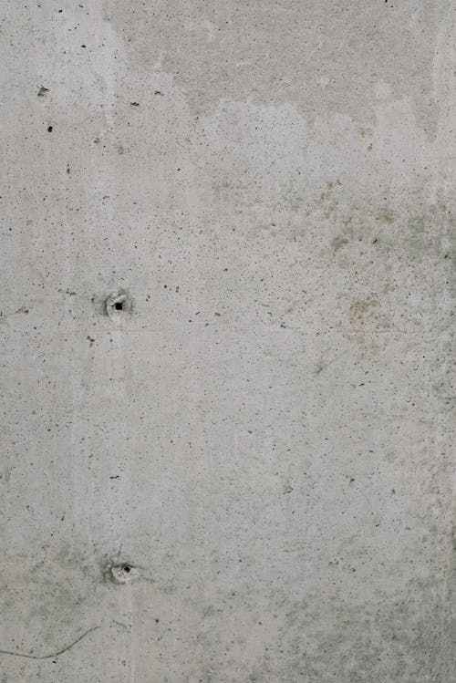 Old shabby concrete wall with small holes