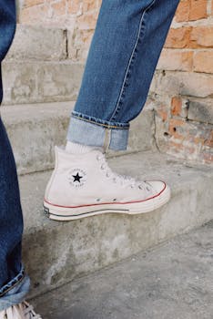 Stylish white sneakers captured on rustic city steps for modern fashion appeal.