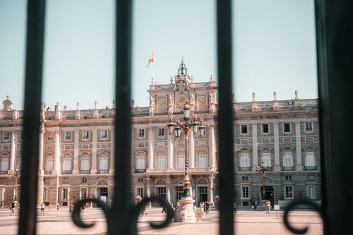 Free View of the Royal Palace of Madrid through elegant wrought iron gates, showcasing its classic architecture. Stock Photo