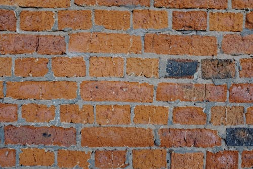Free Background of abstract old shabby brick wall of building on sunny street in city Stock Photo
