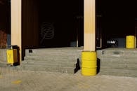 Exterior of modern building with yellow metal trash bins