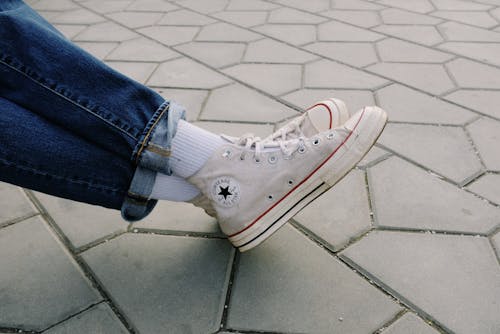 Person Wearing Blue Denim Jeans and White Converse All Star High Top Sneakers