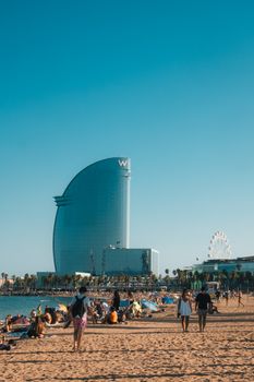 Scenic view of Barcelona beach and the iconic W Hotel on a sunny day.