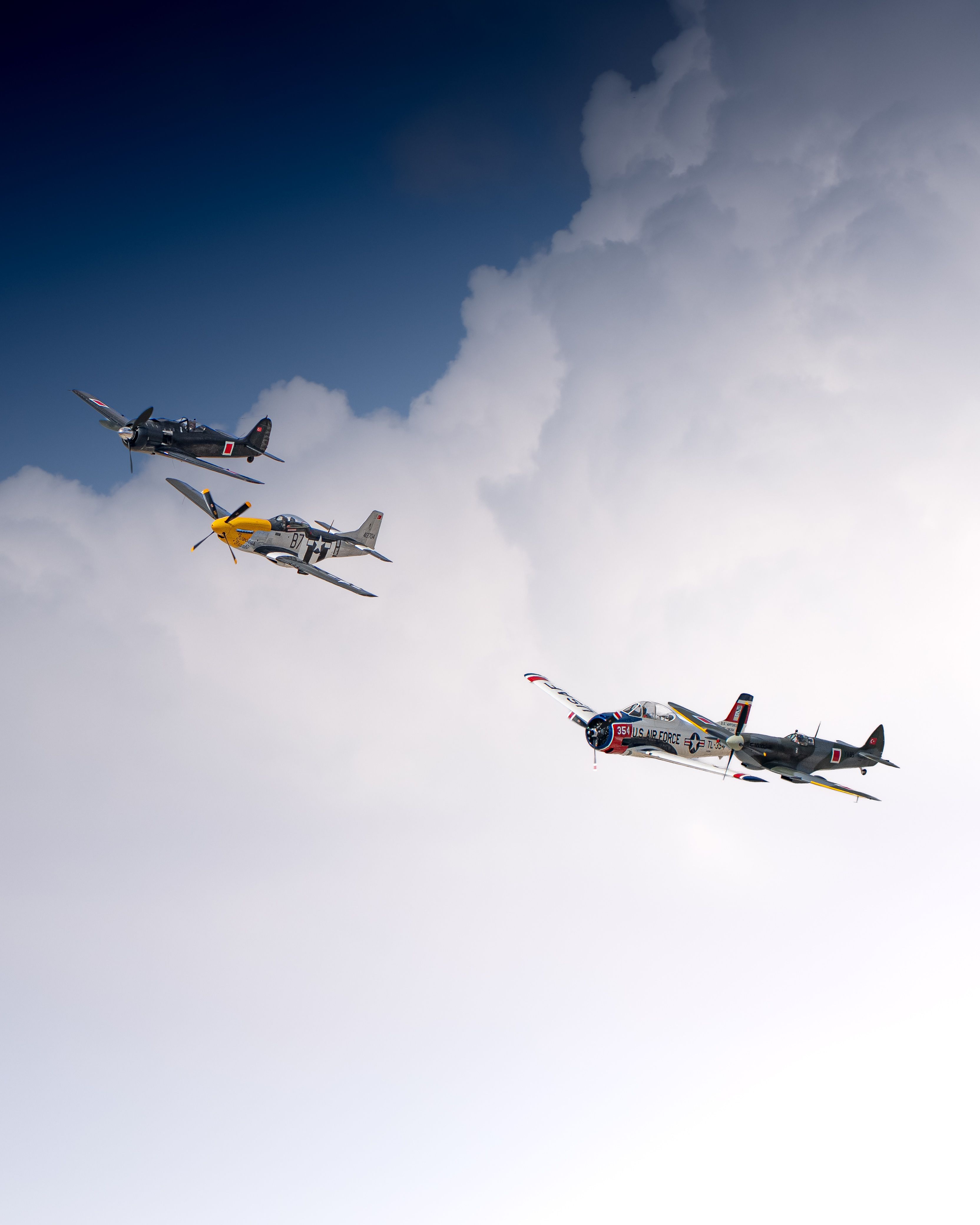 A stunning image of three WWII-era fighter planes flying in formation against a cloudy sky.