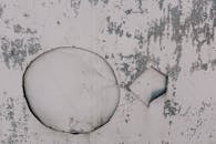 Old shabby metal wall with round hole