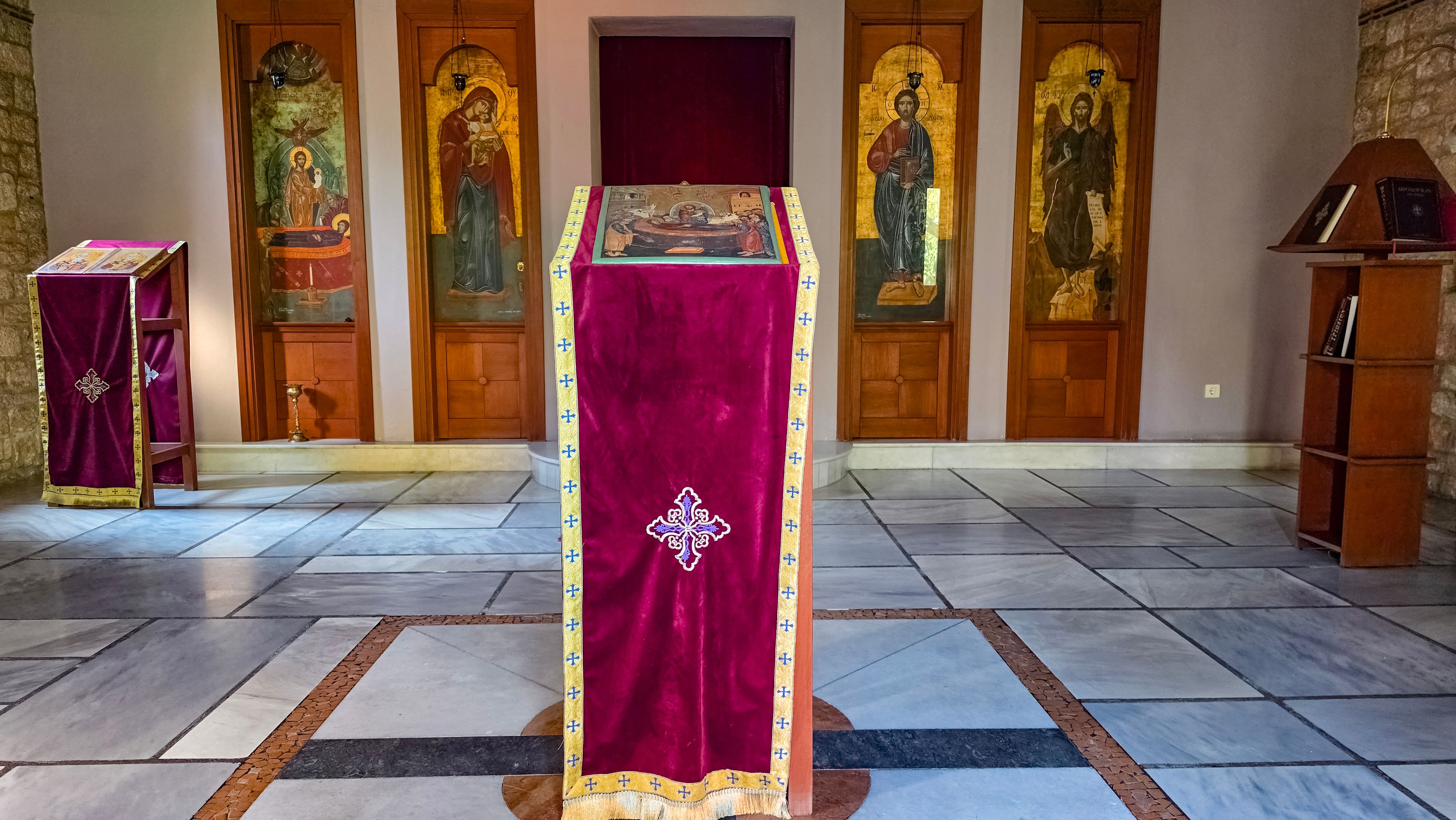 Interior of an Orthodox church featuring religious icons and a central lectern.
