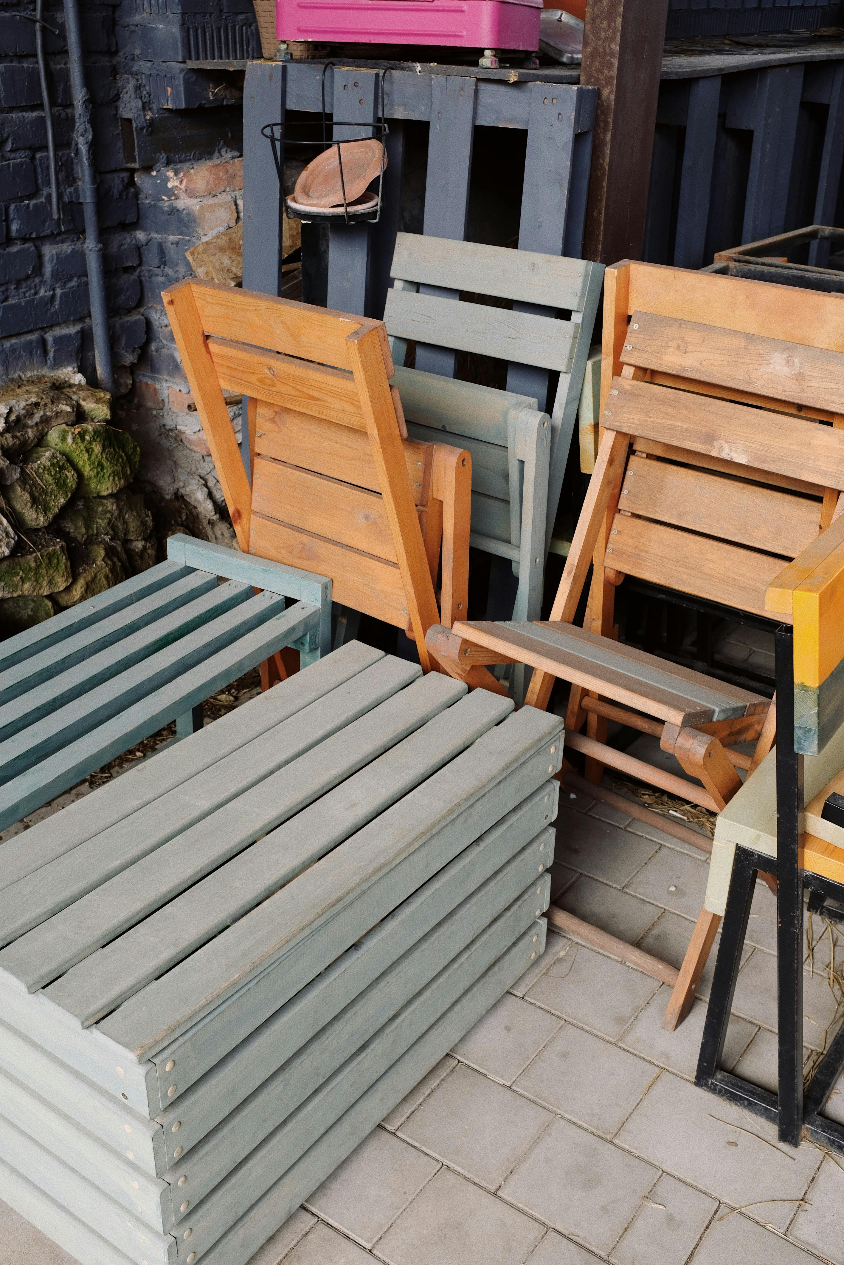 Free Modern wooden chairs and benches placed nearby on concrete floor in closed empty street cafe Stock Photo