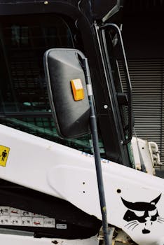 Detailed shot of a parked industrial vehicle's side mirror and exterior.