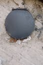 Black Round Lid on Gray Concrete Floor
