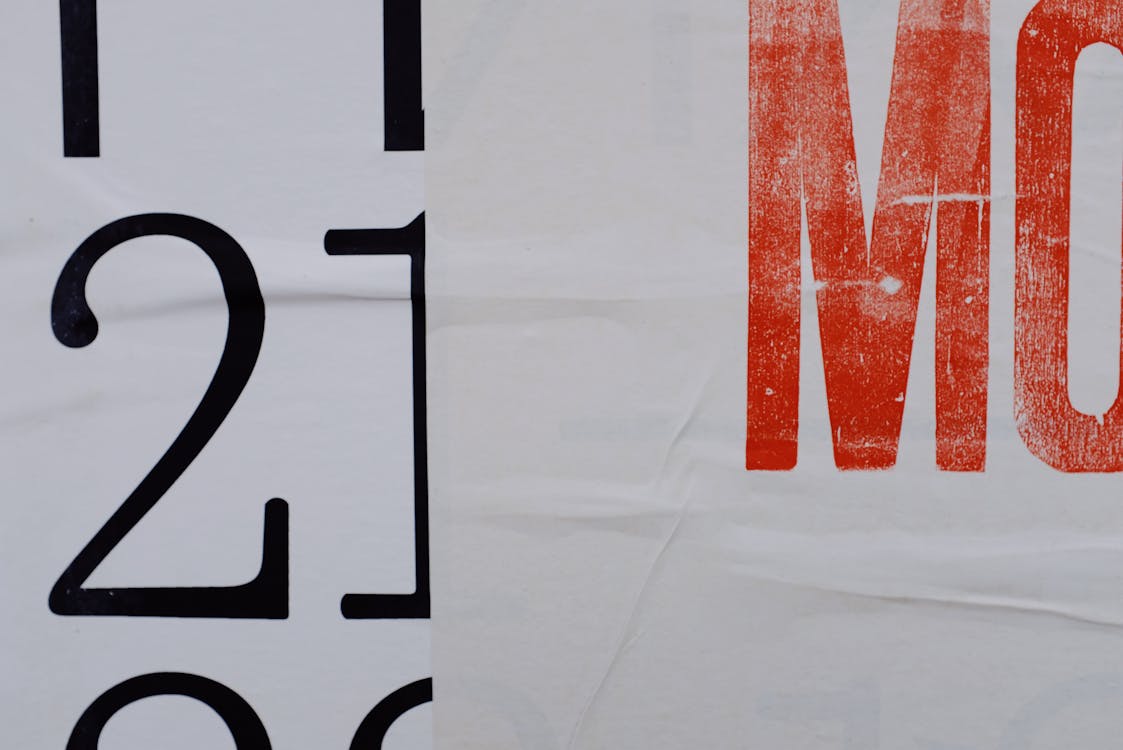 Closeup of letters and numbers printed on white banner placed on wall of modern building on street in city