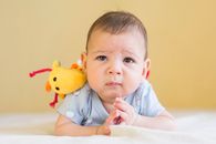 Baby in Blue Shirt Lying on Bed