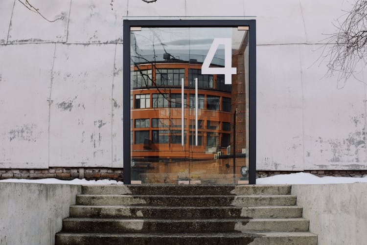 Number Four On Entrance Door And Stairs Of Modern Building