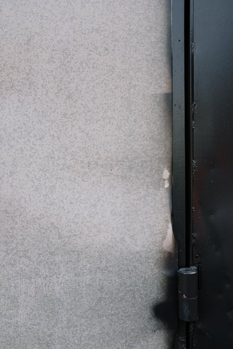 Metal Door Hinge And Grungy Wall