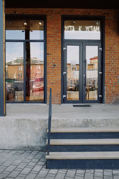 Free Entrance of modern city building with glass door brick walls and steps on street Stock Photo