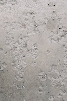 Close-up of a rough and textured concrete surface ideal for backgrounds and overlays.