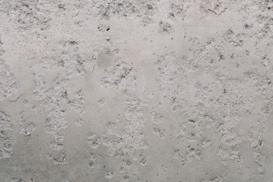 A detailed close-up of a rough and textured concrete wall surface.