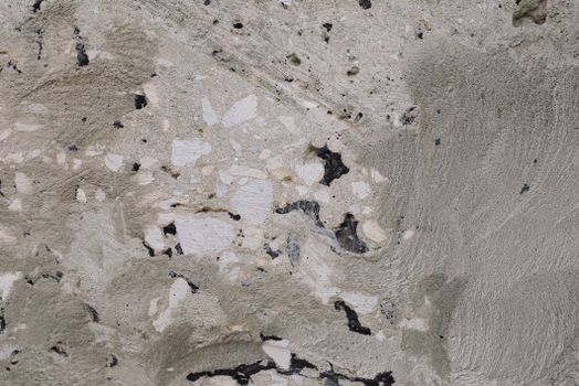 Close-up view of a textured concrete wall, showcasing natural patterns and rough surface details.