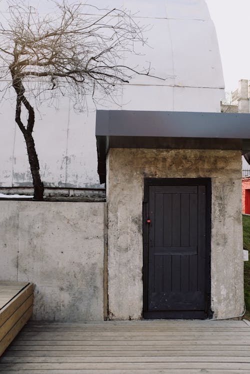 Black Wooden Door on White Concrete Wall