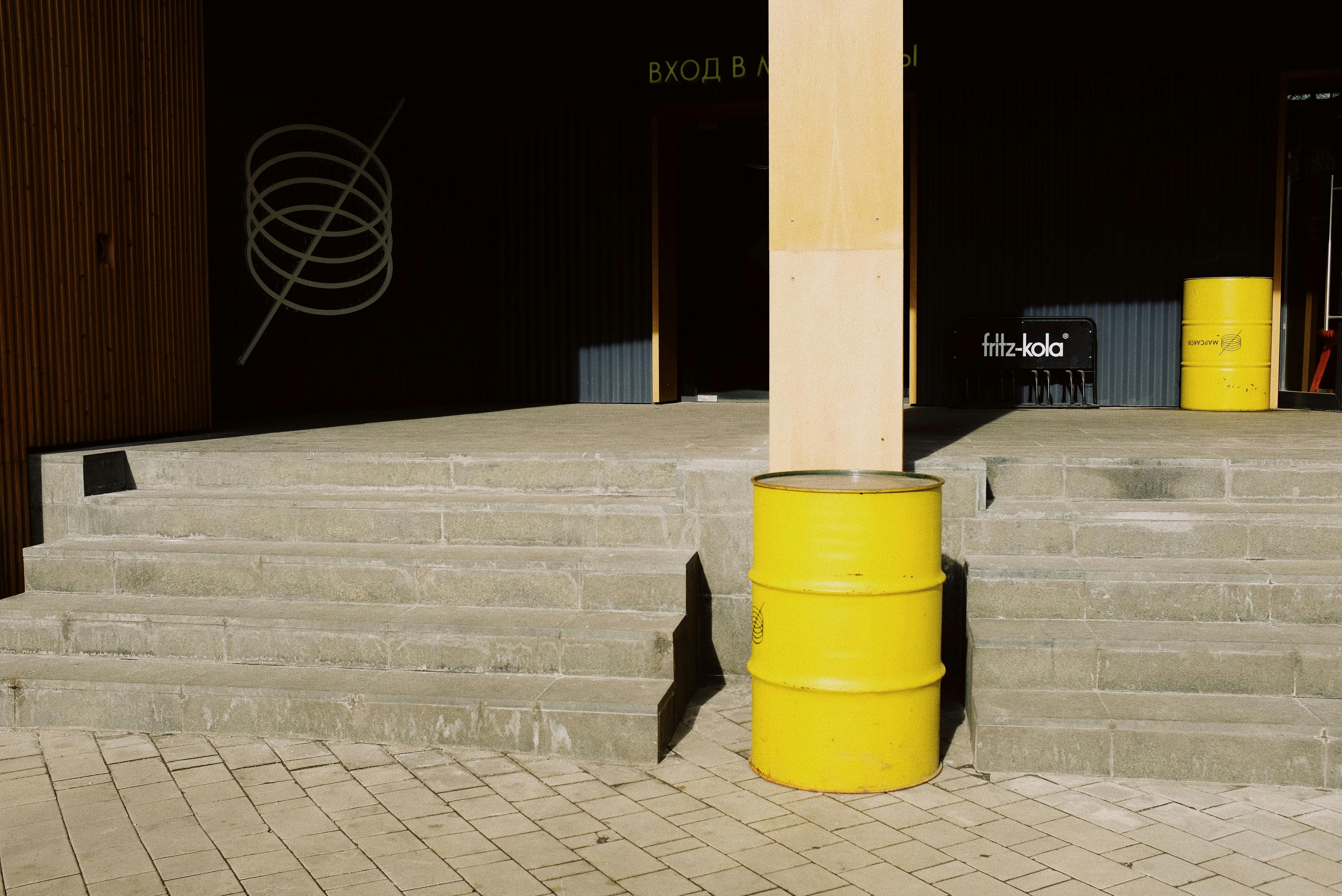 Urban steps with yellow barrels and industrial elements in daylight