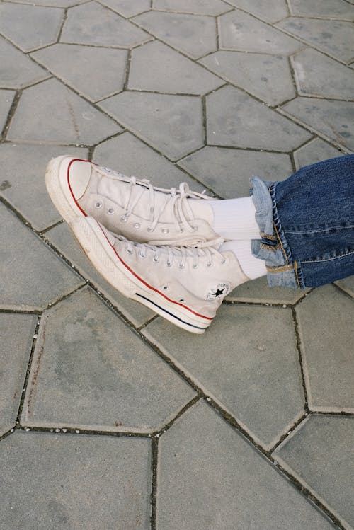 Free Person Wearing Denim Jeans and White Converse Sneakers  Stock Photo