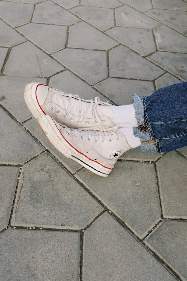 Person Wearing Denim Jeans And White Converse Sneakers 