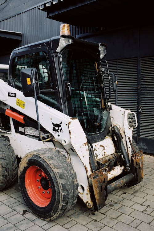 Construction machinery waiting for installation of spare parts and overhauling on paving stones parking