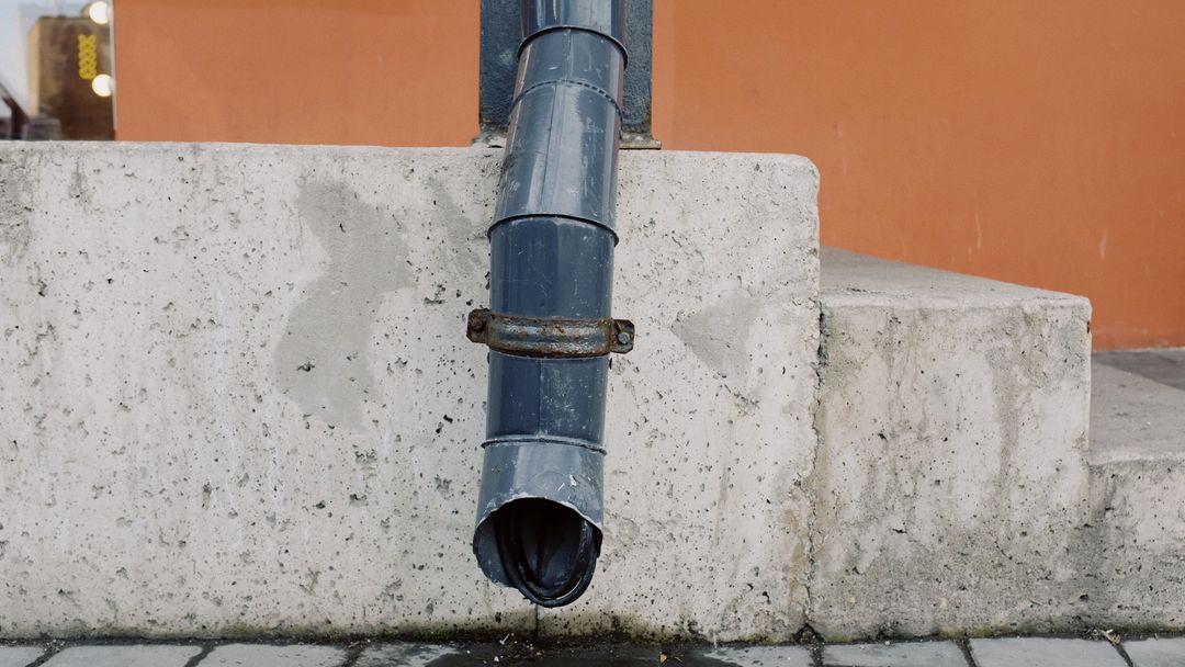 Water dripping from an aged metal drain pipe