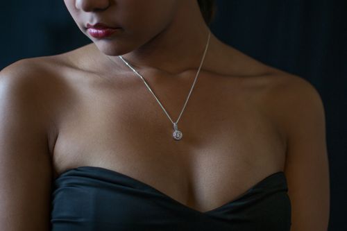 Free Close-up portrait of a woman wearing a diamond necklace and black dress, embodying elegance and style. Stock Photo