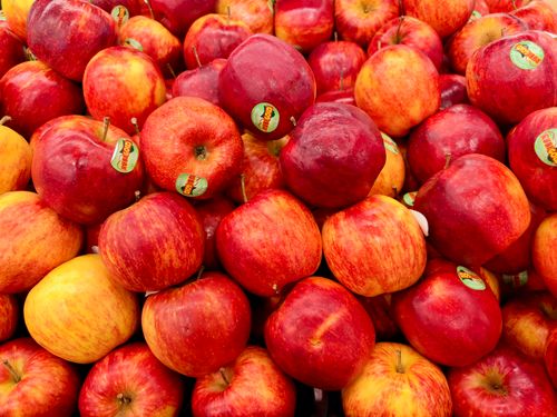 Free A vibrant assortment of ripe red apples with stickers in a market display. Stock Photo
